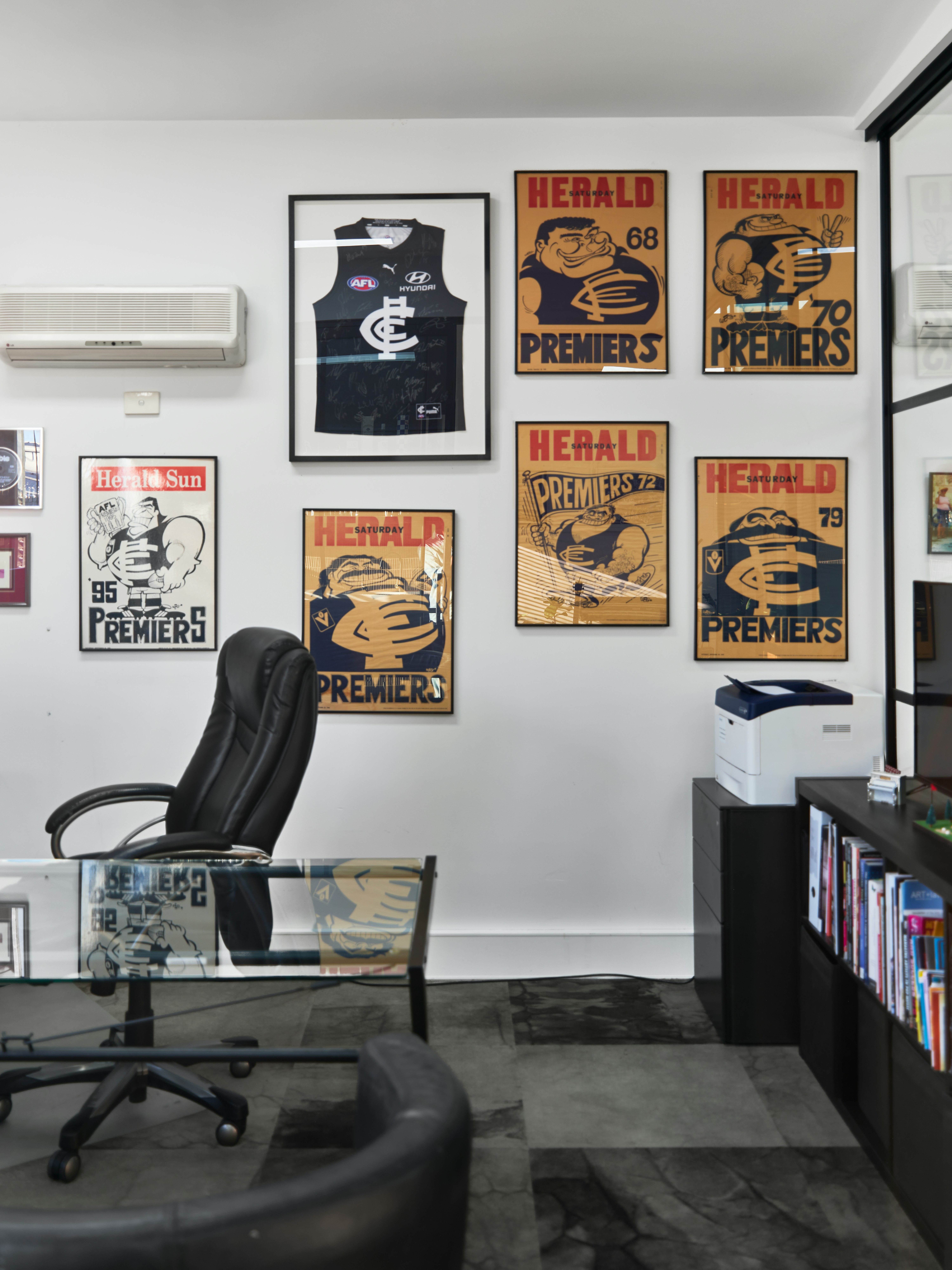 display of framed prints and a framed shirt in an office setting